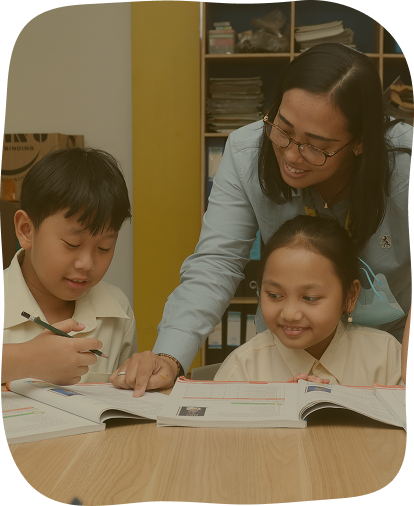 Guru mendampingi dua murid belajar